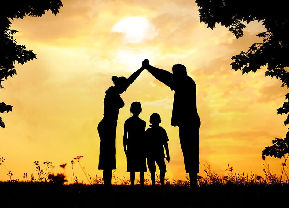 photo of an Alberta family, silhouette of a house with the children covered by the parents